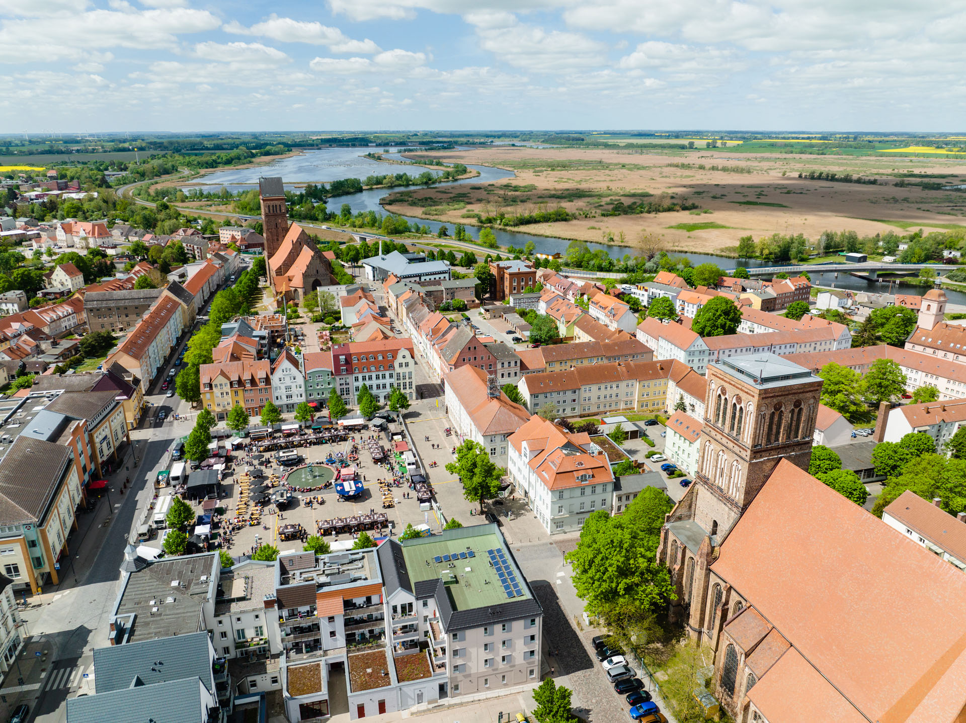 An aerial absorption via the marketplace in Anklam, on the hustle and bustle and behind it the Peene